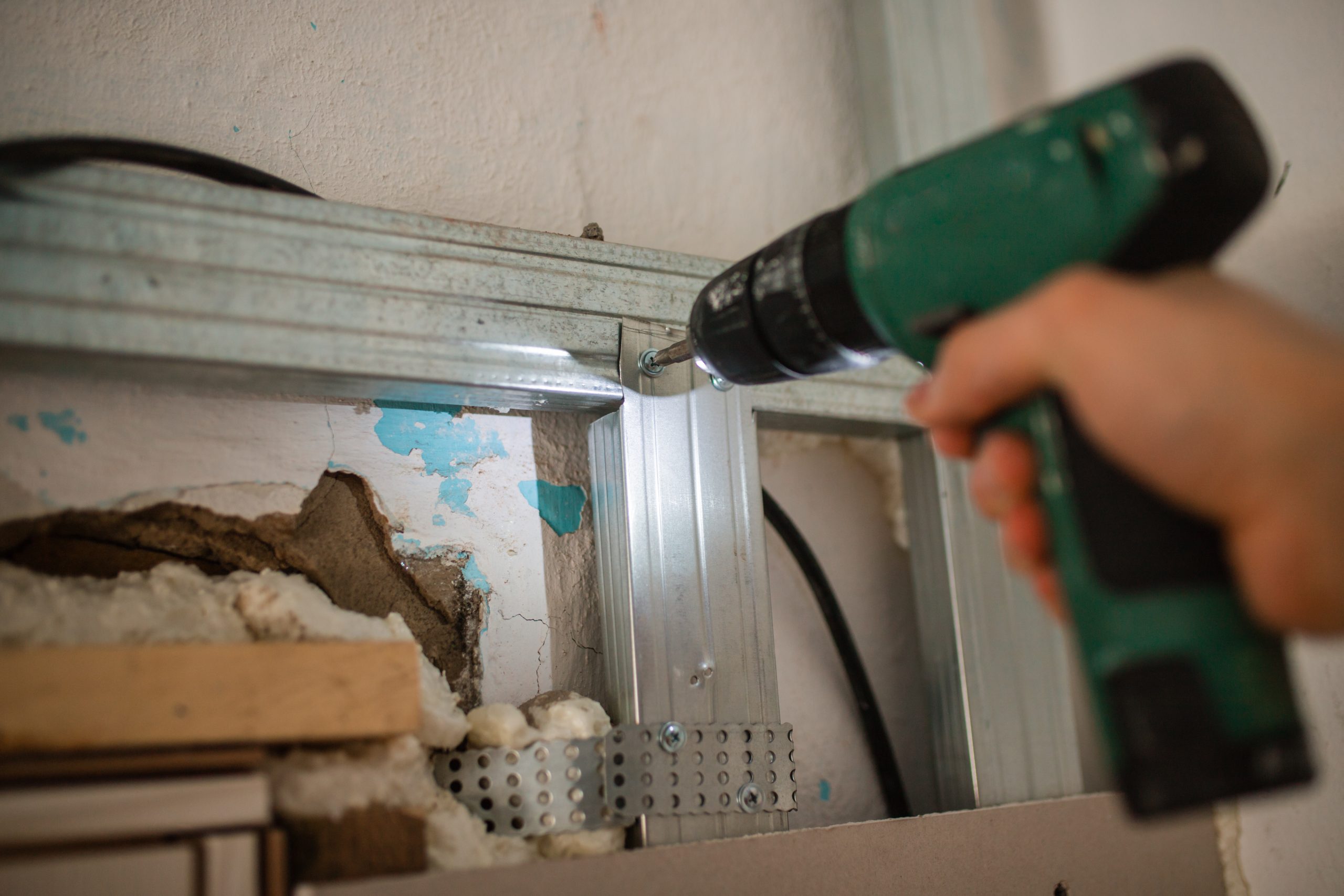 Drives screws into the holder. Close-up, hand with a screwdriver tightening the fastening screw. work with a drill. home repairs. Selective focus